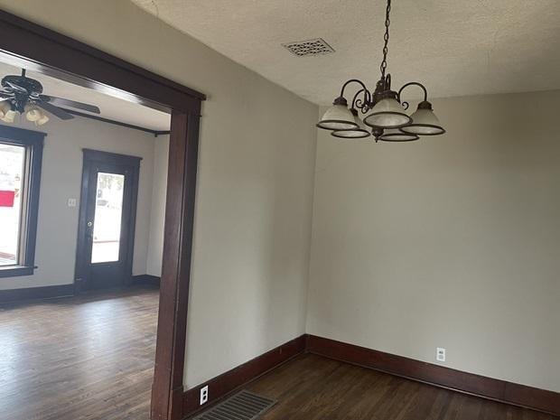 622 Clark St, Marseilles, IL 61341 - unfurnished dining area featuring dark wood-type flooring, a chandelier, baseboards, a textured ceiling, and a ceiling fan