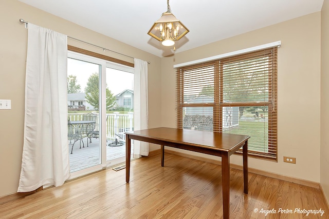 12401 Bigelow Ave, Hebron, IL 60034 - dining area featuring a chandelier, light wood-type flooring, and baseboards