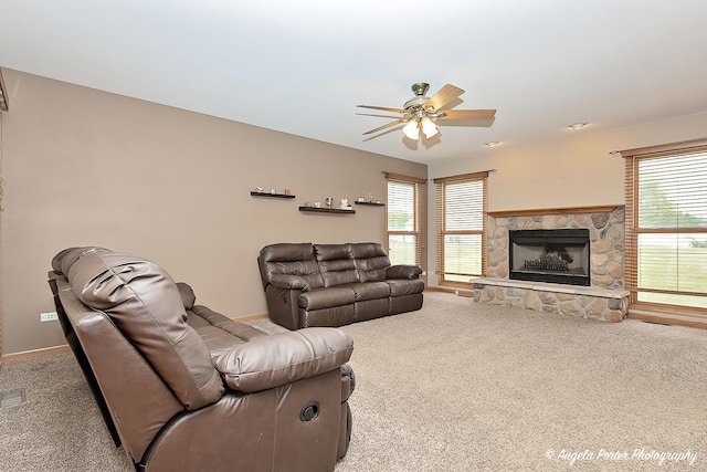 12401 Bigelow Ave, Hebron, IL 60034 - living area with carpet floors, a ceiling fan, a stone fireplace, baseboards, and healthy amount of natural light