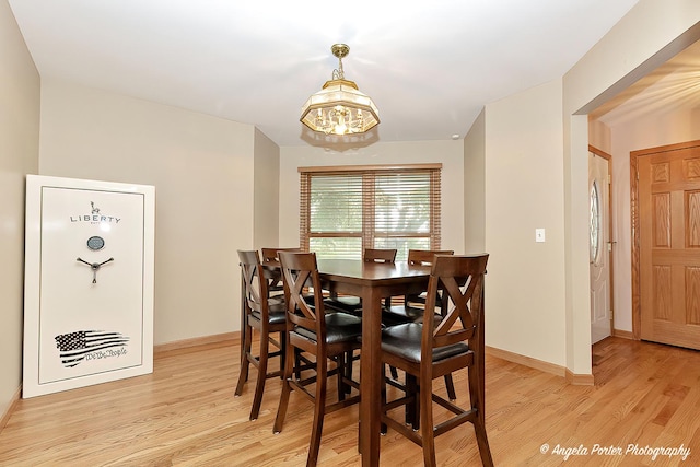 12401 Bigelow Ave, Hebron, IL 60034 - dining area featuring a chandelier, light wood-type flooring, and baseboards