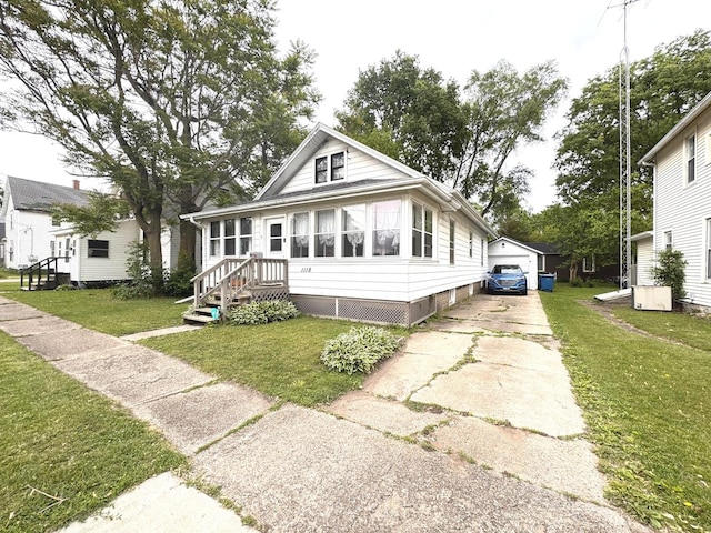 1118 W 4th St, Dixon, IL 61021 - view of front of house with an outdoor structure, a garage, and a front lawn