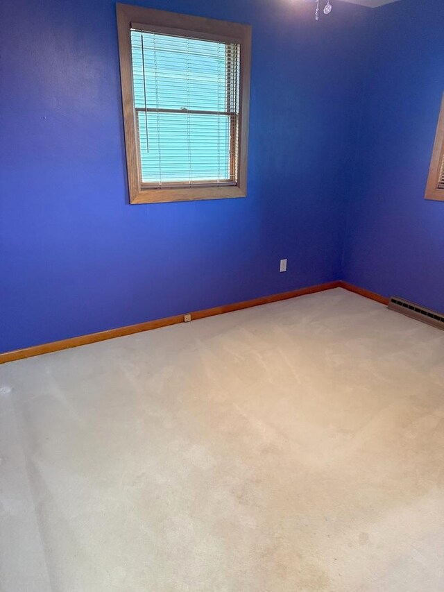 1417 S College Ave, Dixon, IL 61021 - carpeted empty room with baseboards and a baseboard radiator