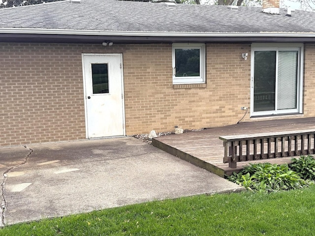 1417 S College Ave, Dixon, IL 61021 - property entrance featuring a shingled roof, a wooden deck, a chimney, and brick siding