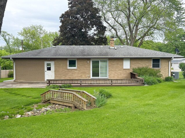 1417 S College Ave, Dixon, IL 61021 - back of house featuring brick siding, central air condition unit, a lawn, and a chimney