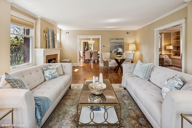 548 Cherry St, Winnetka, IL 60093 - living area with wood finished floors, ornamental molding, a chandelier, a fireplace, and baseboards