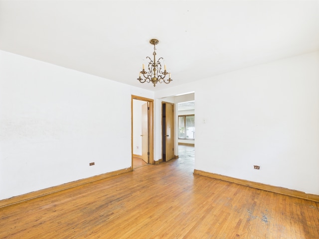 9216 S Ada St, Chicago, IL 60620 - empty room featuring a chandelier, light wood-style flooring, and baseboards
