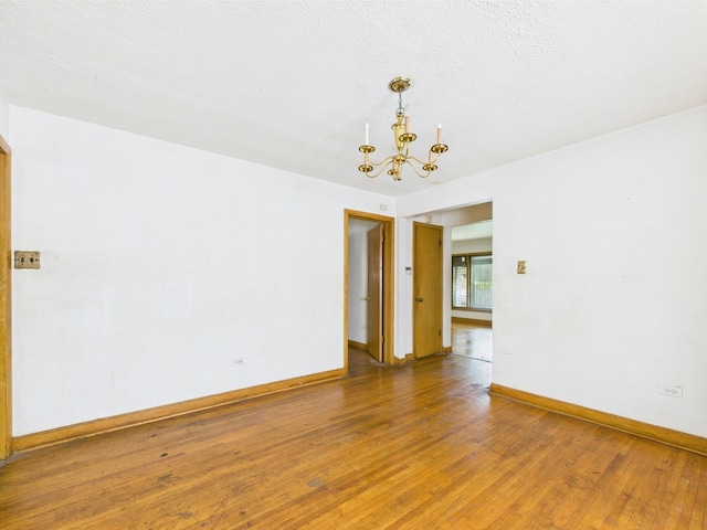 9216 S Ada St, Chicago, IL 60620 - empty room featuring wood-type flooring, a chandelier, and baseboards