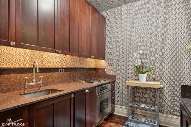 1350 N State Pkwy Unit Gs, Chicago, IL 60610 - kitchen featuring oven, a sink, dark brown cabinetry, decorative backsplash, and wallpapered walls