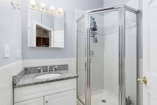 5331 S Harper Ave Unit 1, Chicago, IL 60615 - full bathroom featuring vanity, a shower stall, a wainscoted wall, and tile walls