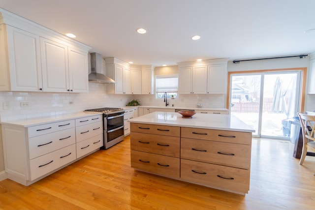13119 Millbank Dr, Plainfield, IL 60585 - kitchen featuring wall chimney range hood, double oven range, light wood-type flooring, and recessed lighting