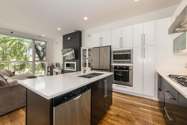1411 W Huron St Unit 2, Chicago, IL 60642 - kitchen featuring appliances with stainless steel finishes, a sink, open floor plan, wall chimney exhaust hood, and light countertops