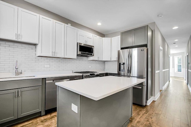 1829 S Kedzie Ave, Chicago, IL 60623 - kitchen featuring stainless steel appliances, a sink, gray cabinets, decorative backsplash, and recessed lighting