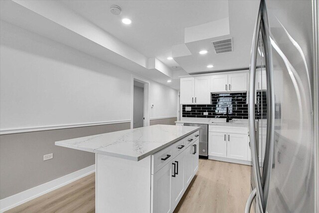 1829 S Kedzie Ave, Chicago, IL 60623 - kitchen featuring appliances with stainless steel finishes, light wood-style floors, white cabinetry, decorative backsplash, and recessed lighting