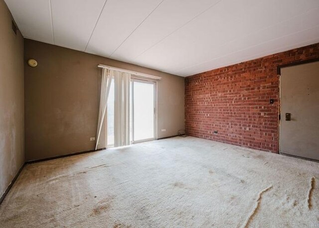 3012 171st St Unit 2E, Hazel Crest, IL 60429 - unfurnished room featuring brick wall and carpet