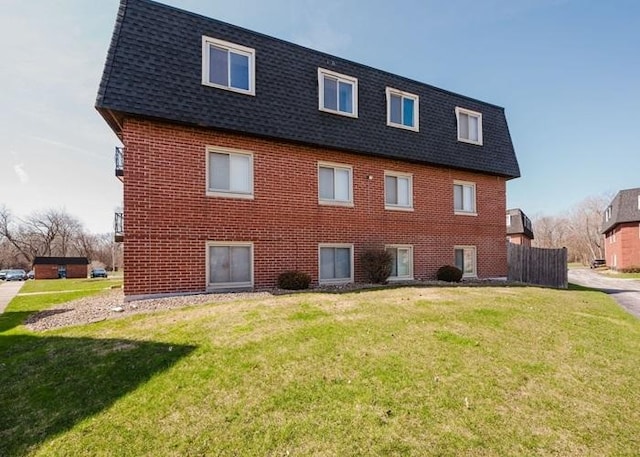 3012 171st St Unit 2E, Hazel Crest, IL 60429 - rear view of house featuring a shingled roof, mansard roof, and a lawn