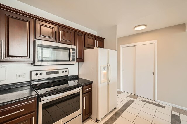 3600 N Lake Shore Dr Unit 1518, Chicago, IL 60613 - kitchen with appliances with stainless steel finishes, dark brown cabinets, light tile patterned floors, dark stone countertops, and inlaid floor details