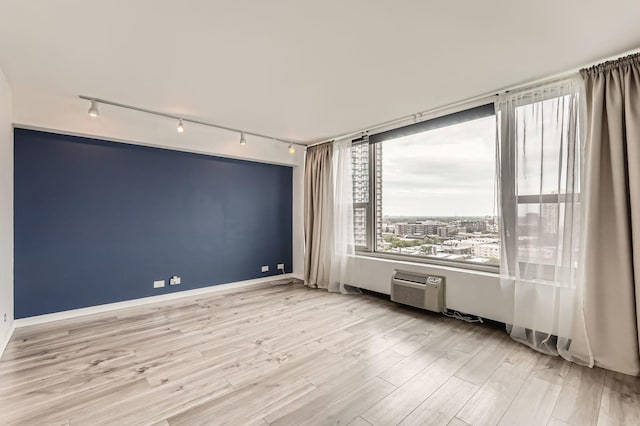 3600 N Lake Shore Dr Unit 1518, Chicago, IL 60613 - unfurnished room featuring rail lighting, wood finished floors, an AC wall unit, and baseboards