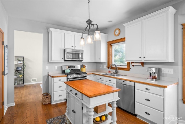39W382 W Mallory Dr, Geneva, IL 60134 - kitchen with stainless steel appliances, white cabinets, wood counters, a kitchen island, and dark wood finished floors