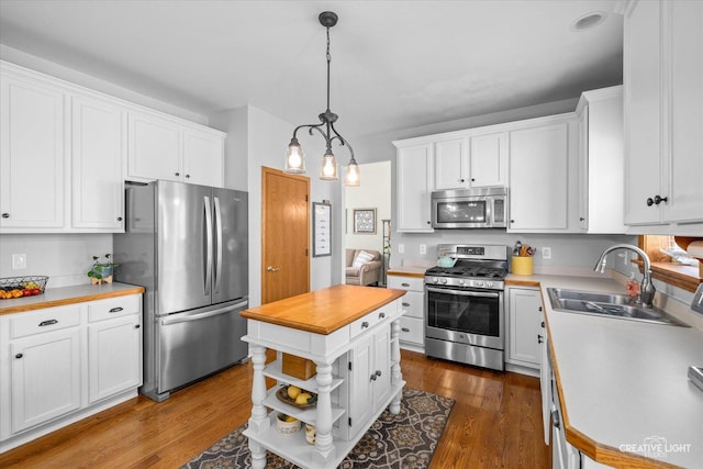 39W382 W Mallory Dr, Geneva, IL 60134 - kitchen featuring appliances with stainless steel finishes, white cabinetry, dark wood finished floors, and pendant lighting