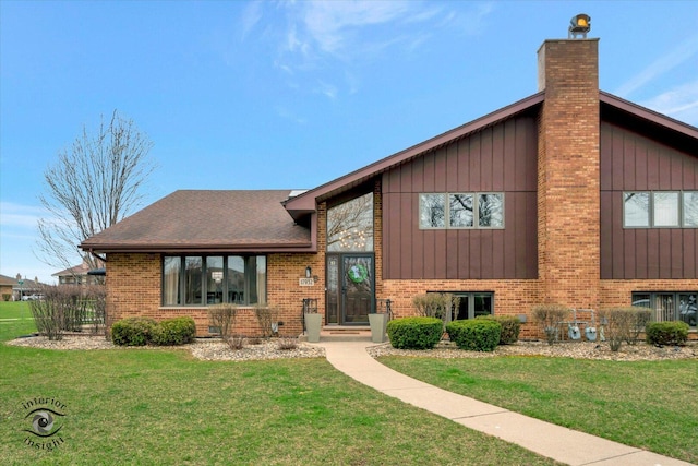 17932 S Alaska Ct Unit 21, Orland Park, IL 60467 - view of front facade featuring brick siding, a front lawn, a chimney, and board and batten siding