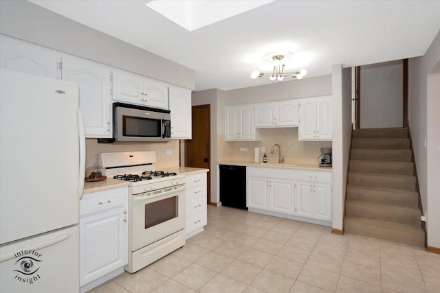 17932 S Alaska Ct Unit 21, Orland Park, IL 60467 - kitchen featuring white appliances, tasteful backsplash, light countertops, white cabinets, and a skylight