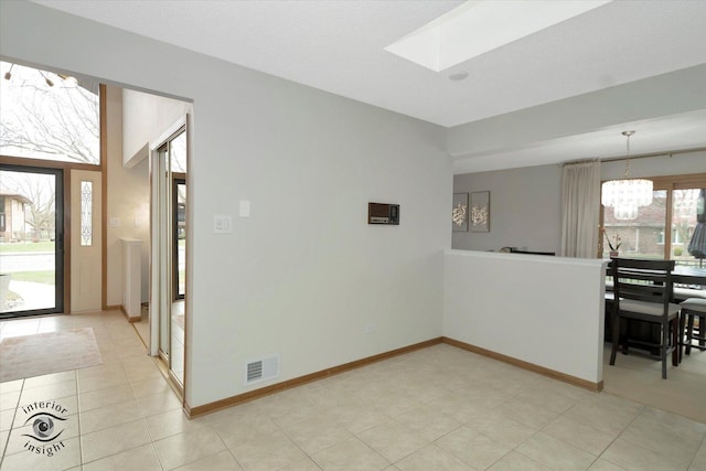 17932 S Alaska Ct Unit 21, Orland Park, IL 60467 - unfurnished dining area featuring a chandelier, a skylight, light tile patterned floors, and baseboards
