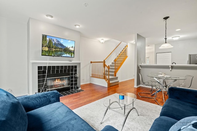 266 Sierra Pass Dr, Schaumburg, IL 60194 - living room with stairway, wood finished floors, a tile fireplace, and baseboards