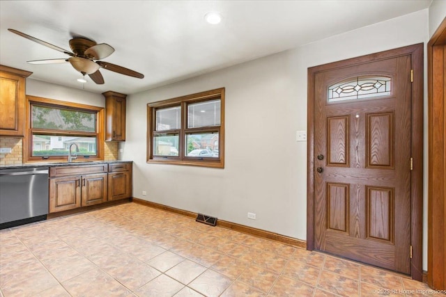 9144 S Trumbull Ave, Evergreen Park, IL 60805 - kitchen with stainless steel dishwasher, a sink, brown cabinets, ceiling fan, and tasteful backsplash