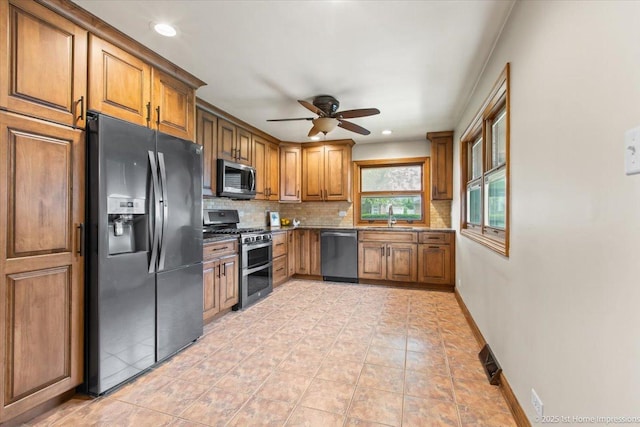 9144 S Trumbull Ave, Evergreen Park, IL 60805 - kitchen featuring appliances with stainless steel finishes, brown cabinets, decorative backsplash, a sink, and a ceiling fan