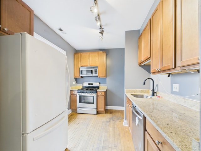 2609 W Rosemont Ave Unit C, Chicago, IL 60659 - kitchen with stainless steel appliances, a sink, light wood finished floors, light stone counters, and baseboards