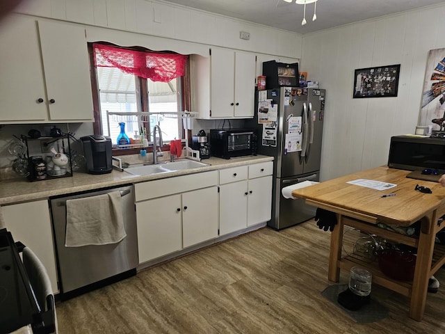 427 W Hurlbut Ave, Belvidere, IL 61008 - kitchen with appliances with stainless steel finishes, a sink, light wood-style floors, light countertops, and white cabinets
