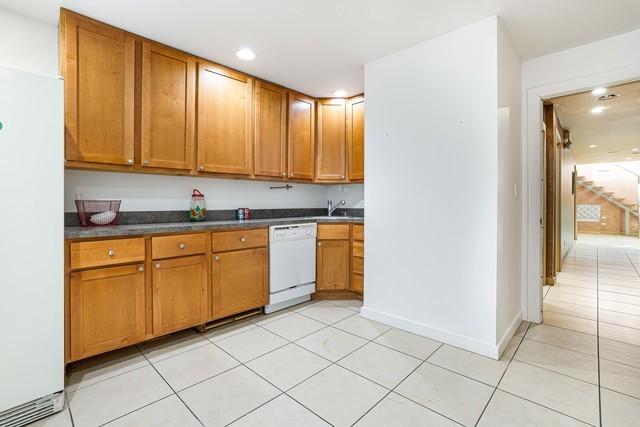 1412 W Division St Unit C-1, Chicago, IL 60642 - kitchen featuring white appliances, dark countertops, brown cabinets, light tile patterned flooring, and recessed lighting