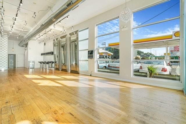 1412 W Division St Unit C-1, Chicago, IL 60642 - empty room with wood finished floors, rail lighting, plenty of natural light, and a chandelier