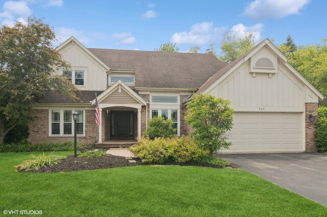 904 Warwick Ln, Lake Zurich, IL 60047 - view of front facade featuring board and batten siding, brick siding, asphalt driveway, and a front yard