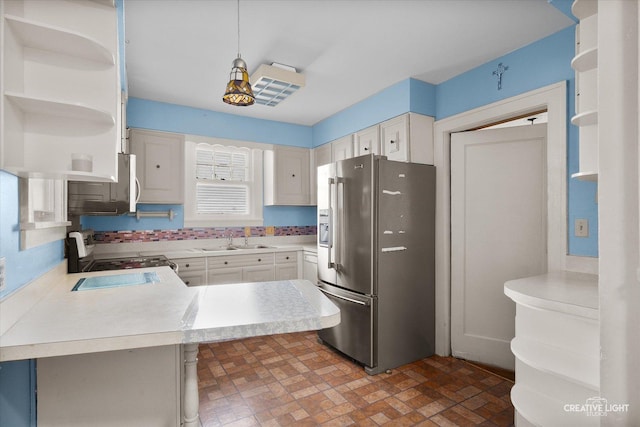 1044 Garfield Ave, Aurora, IL 60506 - kitchen featuring appliances with stainless steel finishes, open shelves, light countertops, brick patterned flooring, and a peninsula