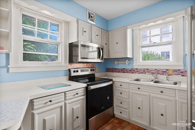 1044 Garfield Ave, Aurora, IL 60506 - kitchen featuring appliances with stainless steel finishes, healthy amount of natural light, light countertops, and brick patterned flooring