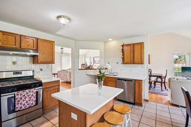 3410 Beckwith Ln, Crete, IL 60417 - kitchen featuring stainless steel appliances, under cabinet range hood, brown cabinetry, and plenty of natural light