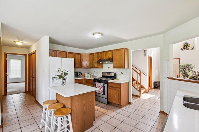 3410 Beckwith Ln, Crete, IL 60417 - kitchen with stainless steel gas range, light tile patterned floors, and brown cabinets