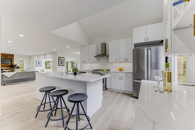 13045 Silver Fox Dr, Lemont, IL 60439 - kitchen featuring wall chimney range hood, stainless steel appliances, light wood-style floors, a kitchen bar, and recessed lighting