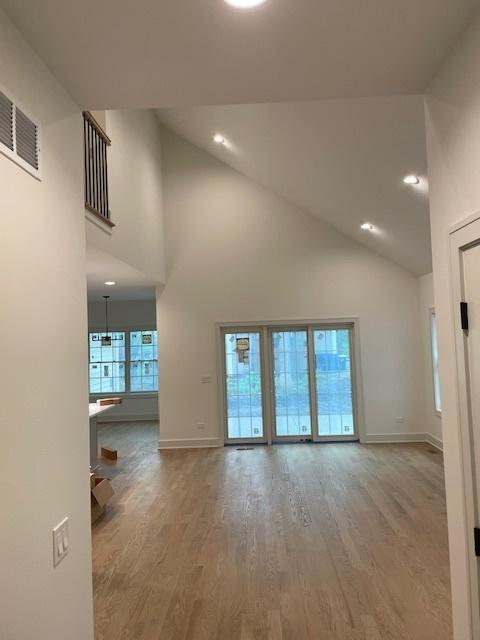 1672 Huntington Ln, Highland Park, IL 60035 - unfurnished living room with high vaulted ceiling, wood finished floors, baseboards, and recessed lighting