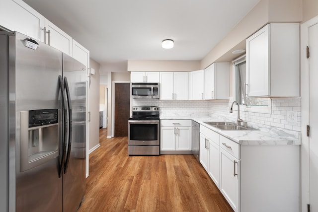 208 N Fremont St, Naperville, IL 60540 - kitchen featuring appliances with stainless steel finishes, a sink, light wood-style floors, decorative backsplash, and white cabinets