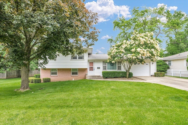 404 Maple Ln, Monticello, IL 61856 - tri-level home featuring concrete driveway, an attached garage, and brick siding