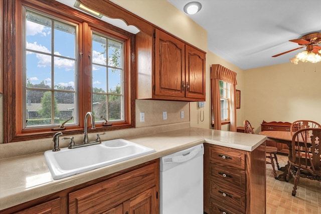 404 Maple Ln, Monticello, IL 61856 - kitchen featuring dishwasher, a sink, brown cabinetry, and healthy amount of natural light