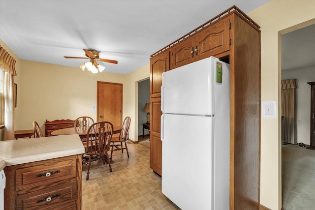 404 Maple Ln, Monticello, IL 61856 - kitchen featuring freestanding refrigerator, ceiling fan, brown cabinets, and light countertops