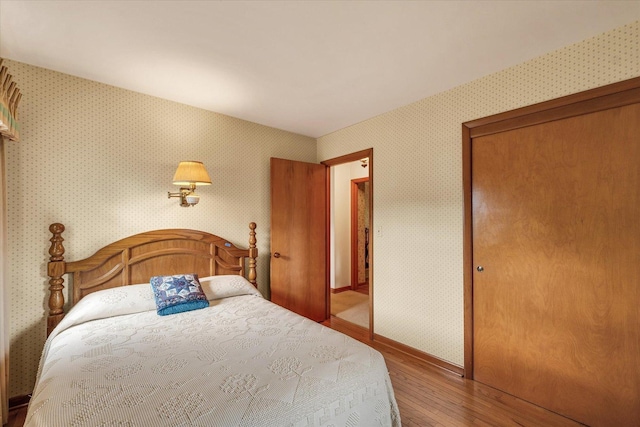 404 Maple Ln, Monticello, IL 61856 - bedroom with wood-type flooring, wallpapered walls, a closet, and baseboards