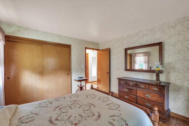 404 Maple Ln, Monticello, IL 61856 - bedroom featuring wood finished floors, baseboards, a closet, and wallpapered walls