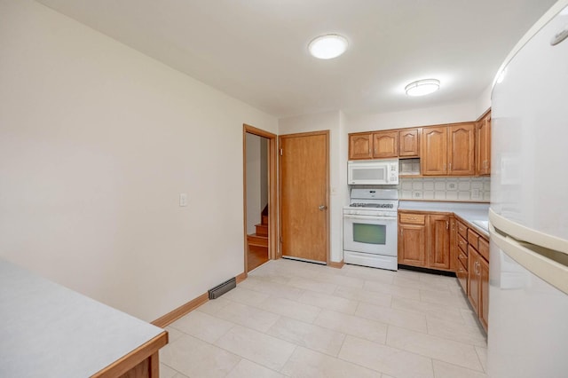408 E Fabyan Pkwy, Batavia, IL 60510 - kitchen with white appliances, tasteful backsplash, light countertops, brown cabinets, and baseboards