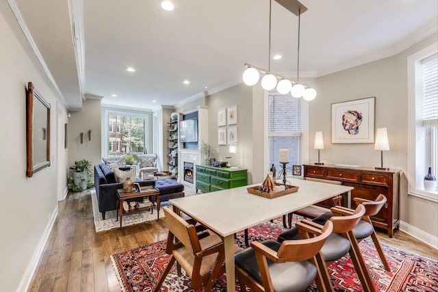 1908 N Whipple St Unit 2, Chicago, IL 60647 - dining room with crown molding, hardwood / wood-style flooring, a lit fireplace, baseboards, and recessed lighting
