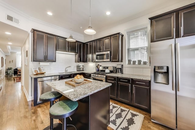 1908 N Whipple St Unit 2, Chicago, IL 60647 - kitchen with appliances with stainless steel finishes, dark brown cabinets, a sink, a center island, and light stone counters