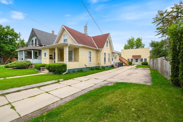 572 Walnut Ave, Elgin, IL 60123 - view of side of home featuring a chimney, a porch, concrete driveway, and roof with shingles